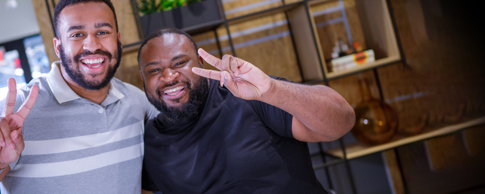 Two Men Of Color Showing The Peace Sign In A Retail Environment (1)